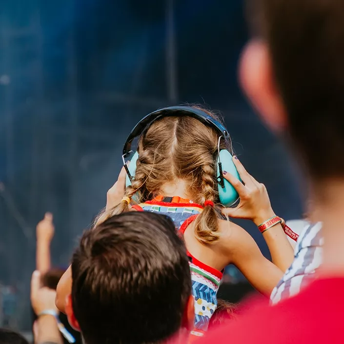 Kind mit Gehörschutz beim Konzert