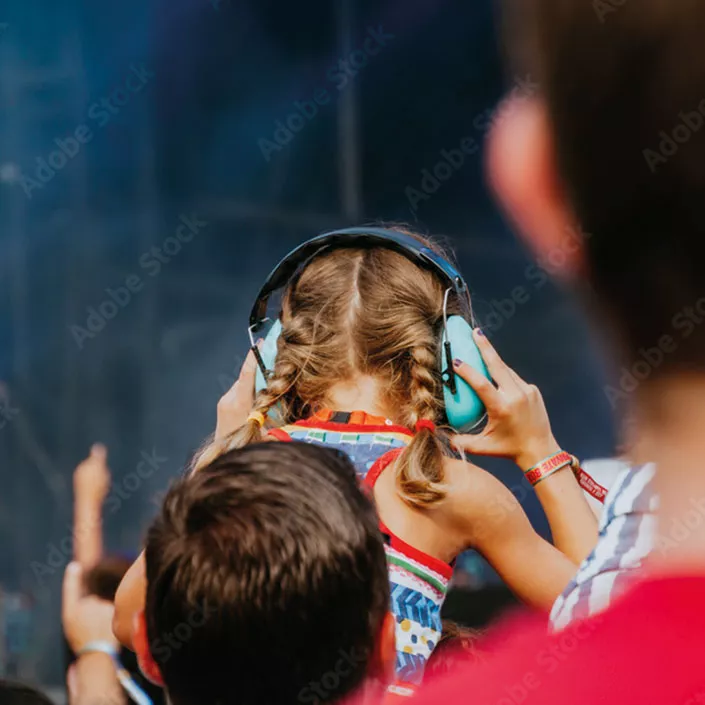 Kind mit Gehörschutz beim Konzert