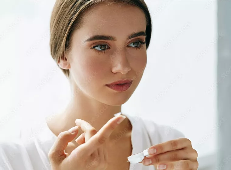 Frau mit Kontaktlinse auf dem Finger